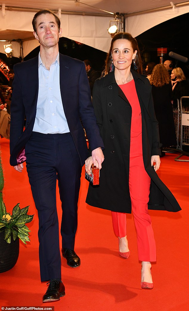Pippa a opté pour une combinaison rouge avec des escarpins assortis et un trench-coat noir, tandis que James avait l'air pimpant dans un costume bleu avec une chemise bleu clair