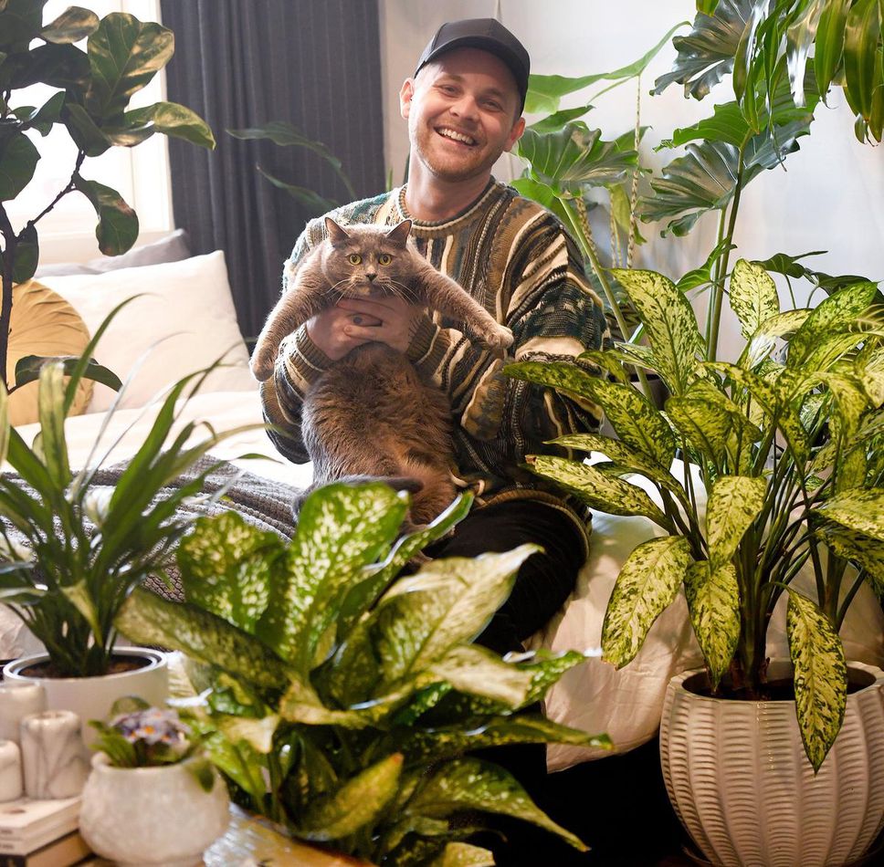 Mikel Coates et son chat Muzzer dans sa jungle végétale urbaine.
