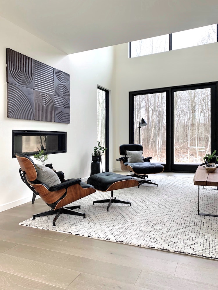 salon blanc moderne avec mobilier noir et tapis à motifs