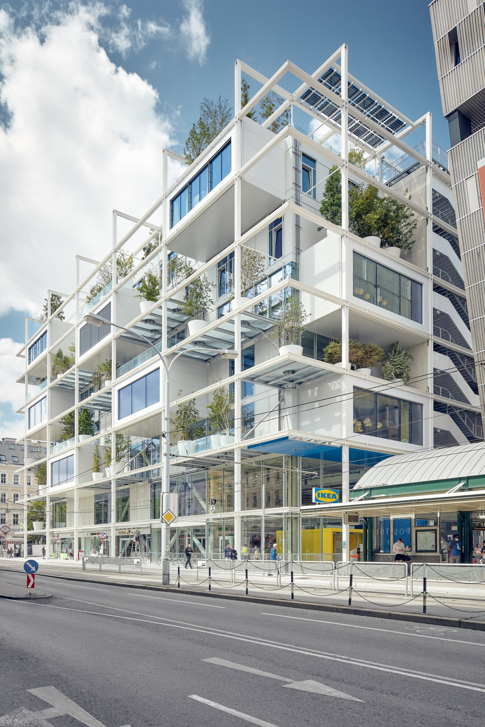 un bâtiment moderne en verre dans une rue animée