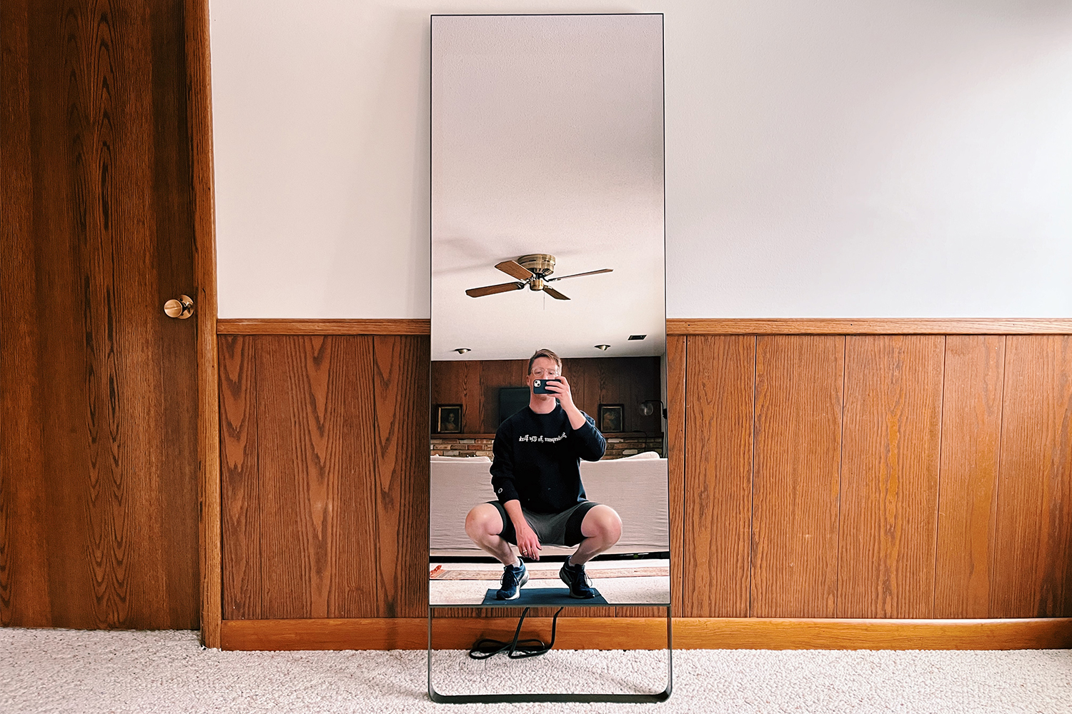 Le miroir d'exercice original, de Mirror, appuyé contre un mur à la maison.  Nous avons examiné l'appareil de fitness à domicile pour trouver les avantages et les inconvénients.